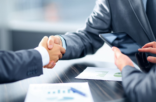 Business professionals shaking hands after discussing strategies to protect their bank accounts from garnishment.